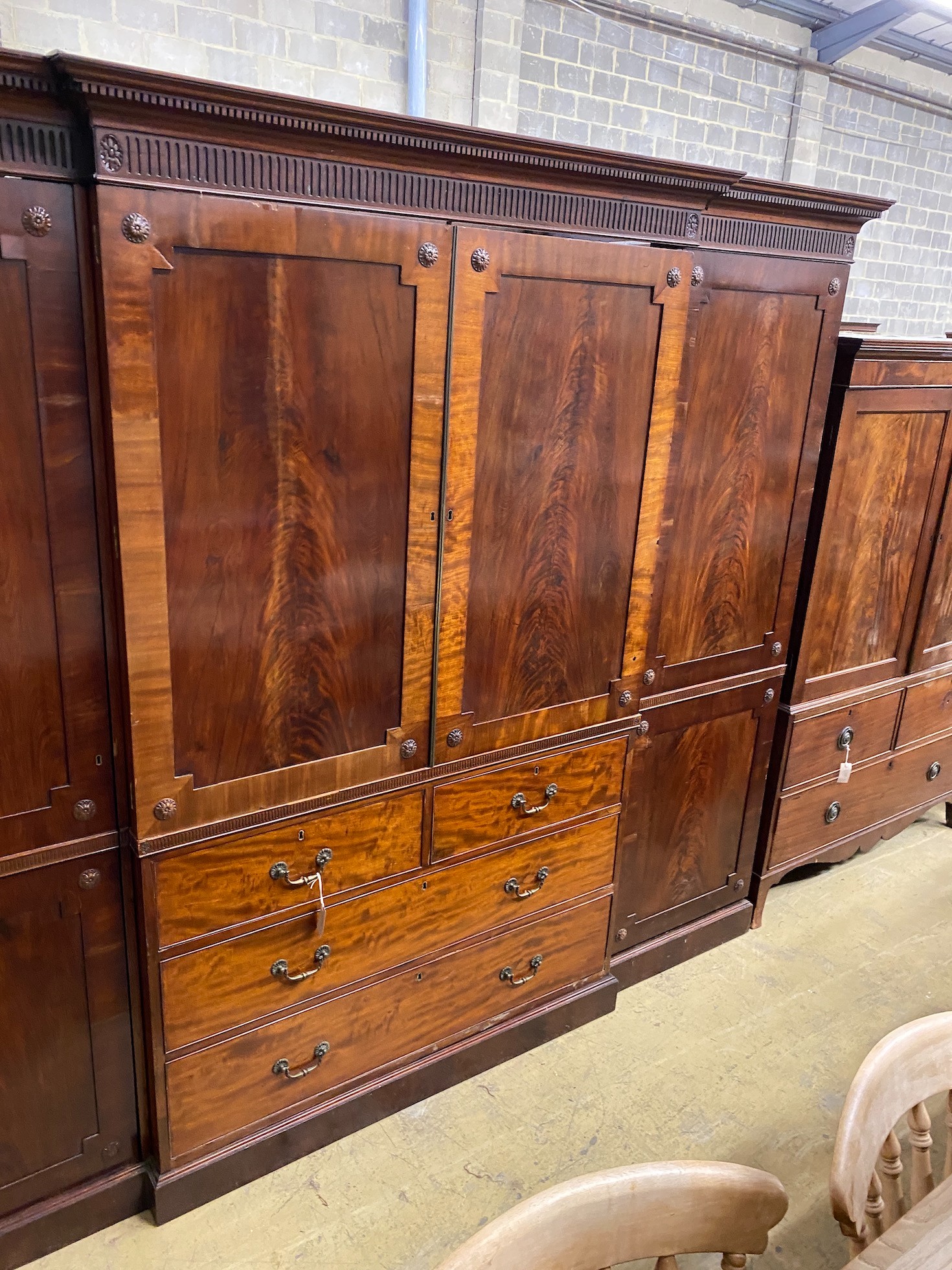 An Edwardian mahogany breakfront wardrobe, with two doors enclosing trays and four drawers flanked by hanging compartments, width 256cm, height 209cm